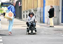 Ana Rosa se dipone a cruzar con su silla de ruedas un paso de peatones de la avenida de la Libertad.