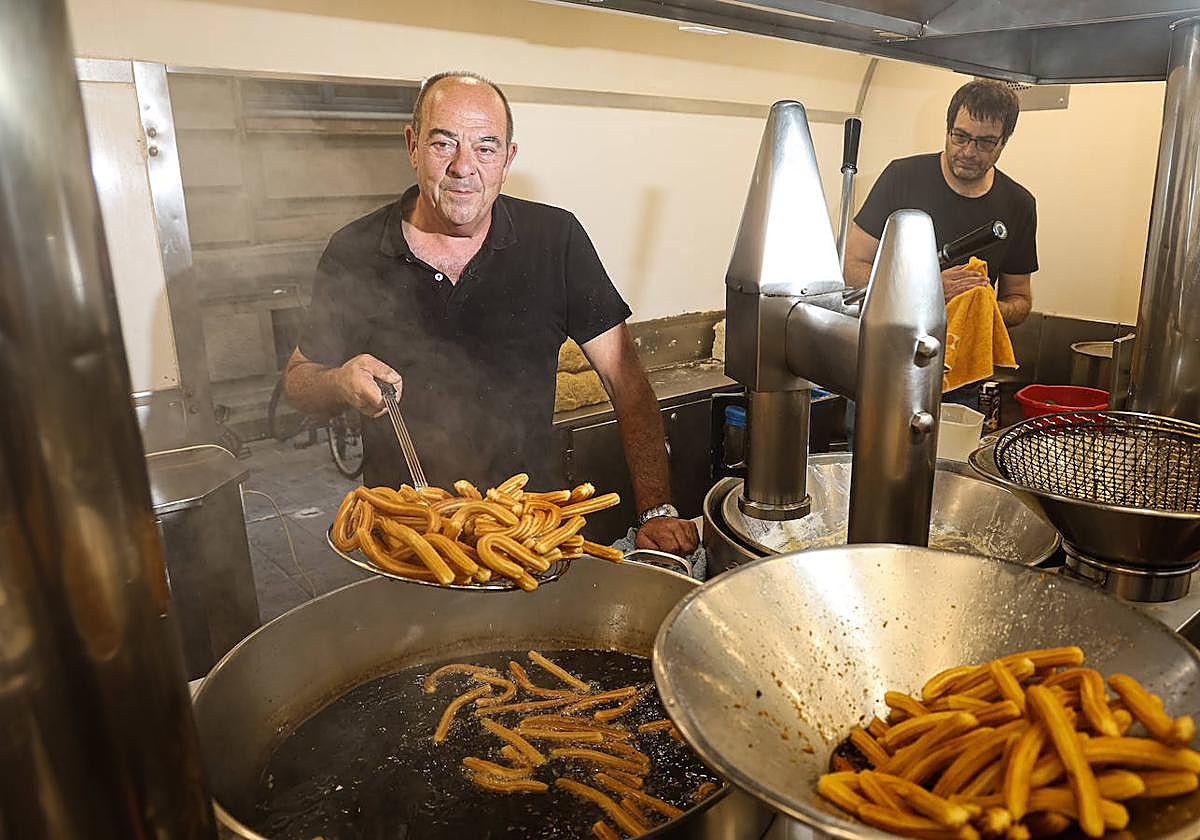 Arturo Manchado padre, junto a su hijo Arturo mientras fríen unos churros.