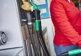 Una mujer reposta en una gasolinera.