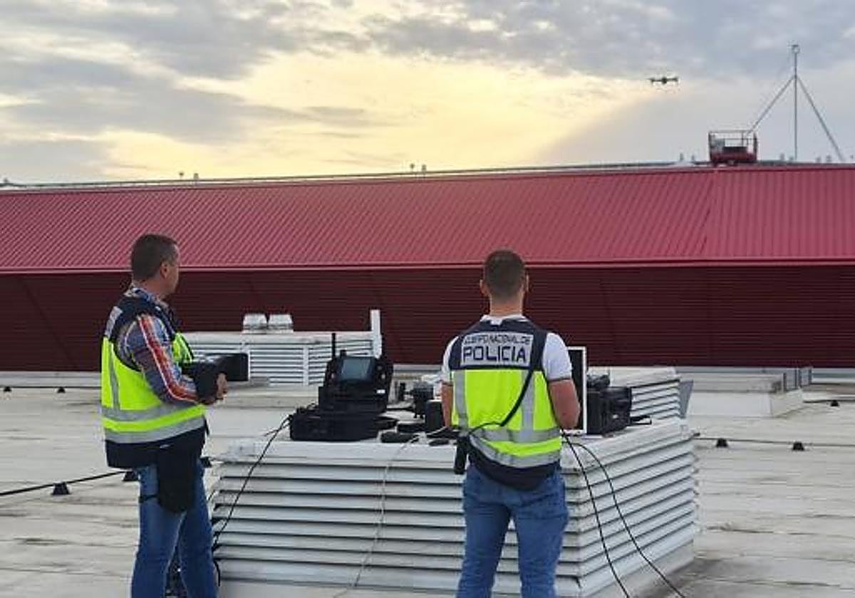 Dos agentes de la Policía Nacional manejan un dron sobre el estadio de fútbol