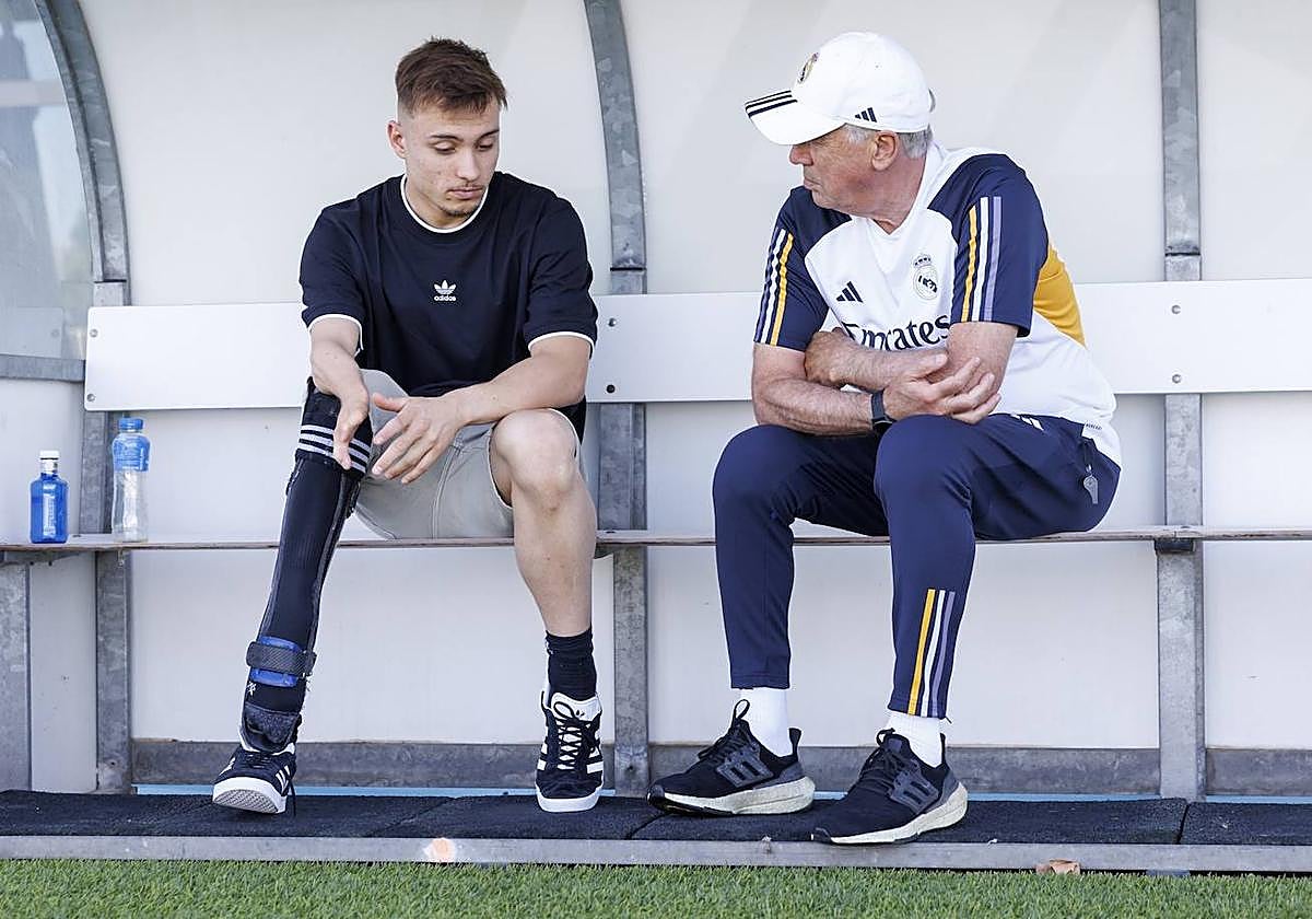 Iñigo Llopis y Carlo Ancelotti conversan en el banquillo del campo de entrenamiento del Real Madrid en Valdebebas.