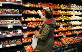 Una consumidora en la sección de verduras de un supermercado