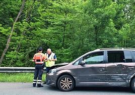 Un agente de la Ertzaintza realiza un control de alcoholemia a un conductor tras un accidente.