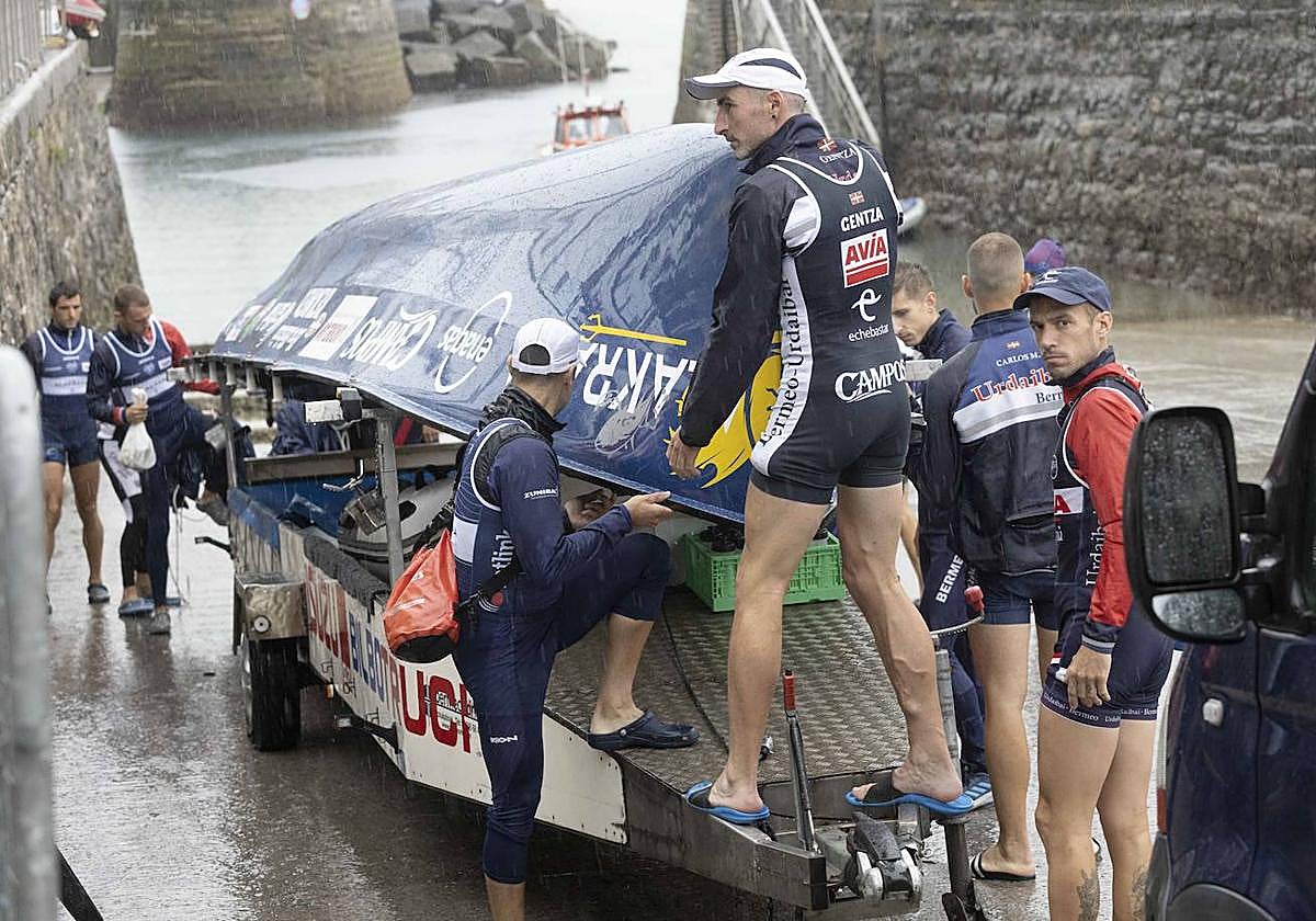 Los remeros de Urdaibai cargan la trainera en el remolque tras finalizar su entrenamiento.