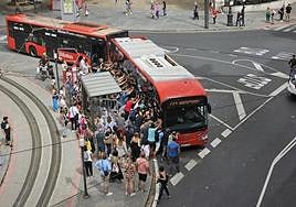Decenas de personas empujan el autobús ante una gran expectación.