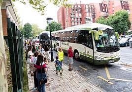 Un grupo de padres y madres espera a sus hijos en la parada de autobús del colegio Toki Alai de Irun, situada en el barrio de Arbes.