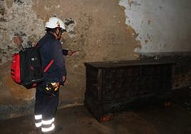 Un operario muestra el nivel del agua en un portal en Mutriku.