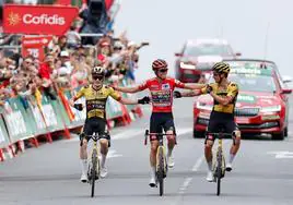 Triplete. Jonas Vingegaard, Sepp Kuss y Primoz Roglic celebran el triunfo del americano en la Vuelta, este sábado en Guadarrama, en una imagen que recordó a la de Greg Lemond y Bernard Hinaul en Alpe d'Huez,en el Tour de 1986. AFP