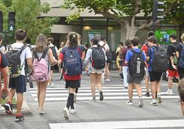 Un grupo de escolares ajeno a esta información cruza por un paso de cebra en una calle de Donostia.