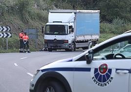 Agentes de la Ertzaintza junto a la moto y el camión implicados en el accidente.