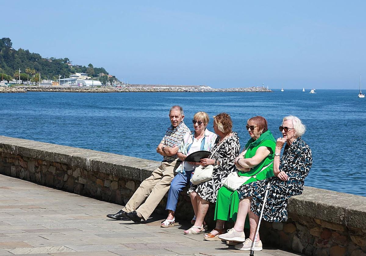 Una cuadrilla de cinco personas mayores disfrutan de la buena temperatura en Hondarribia.
