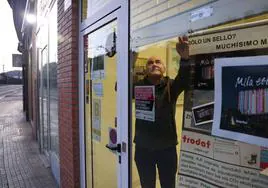 Un hombre baja la persiana tras cerrar un negocio en Usurbil.