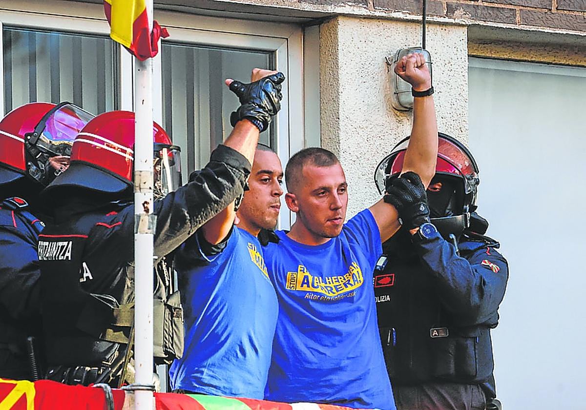 Zelaia y Barbado levantan el puño al ser detenidos ayer.