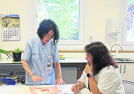 Maribel Pagola y Begoña Antunez observan varios dibujos realizados por las chicas durante su recuperación.