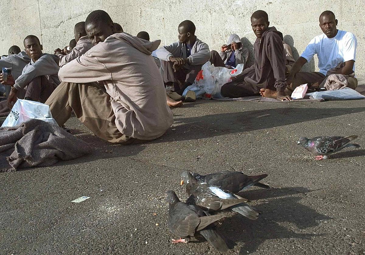Inmigrantes son fotografiados sentados, tras su llegada a la isla española de Gran Canaria, en las Islas Canarias.