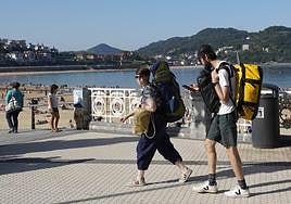 Dos turistas pasean por el paseo de La Concha.