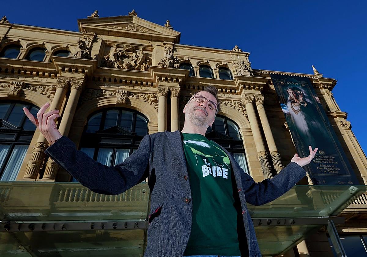 Josemi Beltrán posa frente al teatro Victoria Eugenia, de cuya fachada cuelga el cartel de esta edición del festival, protagonizado por Itziar Ituño.