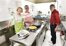 Eloy Ubegun, en el centro, ayudado en la cocina de la residencia por la voluntaria Isabel y el residente Agustín.