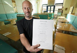 Xanet Garmendia, responsable del restaurante Iñausti, señala el menú del día del que dispone actualmente.