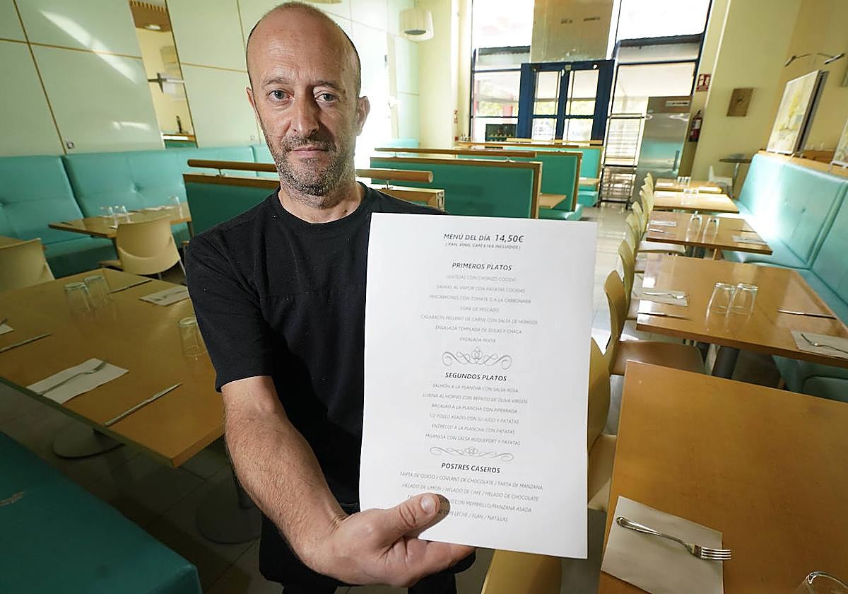 Xanet Garmendia, responsable del restaurante Iñausti, señala el menú del día del que dispone actualmente.