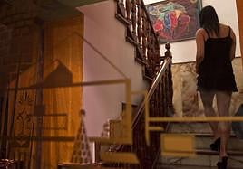 Una mujer sube unas escaleras en un chalet donde es obligada a prostituirse.