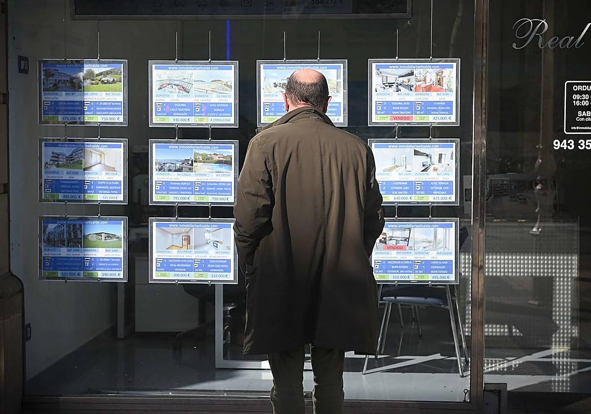 Un hombre observa el escaparate de una agencia inmobiliaria de San Sebastián.
