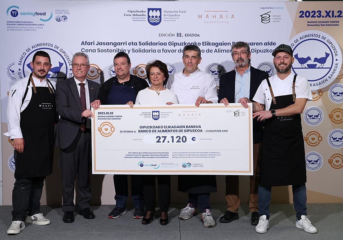 Representantes institucionales y del Banco de Alimentos sostienen el 'cheque' del dinero recaudado.