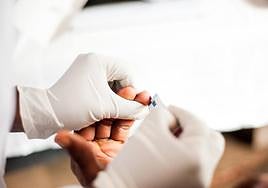 Un sanitario toma una muestra de sangre a un paciente.