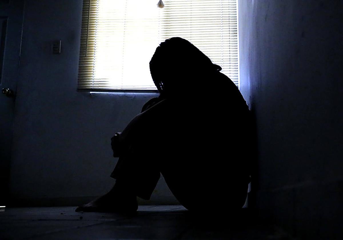 La silueta de una mujer víctima de violencia machista se recorta ante una ventana.