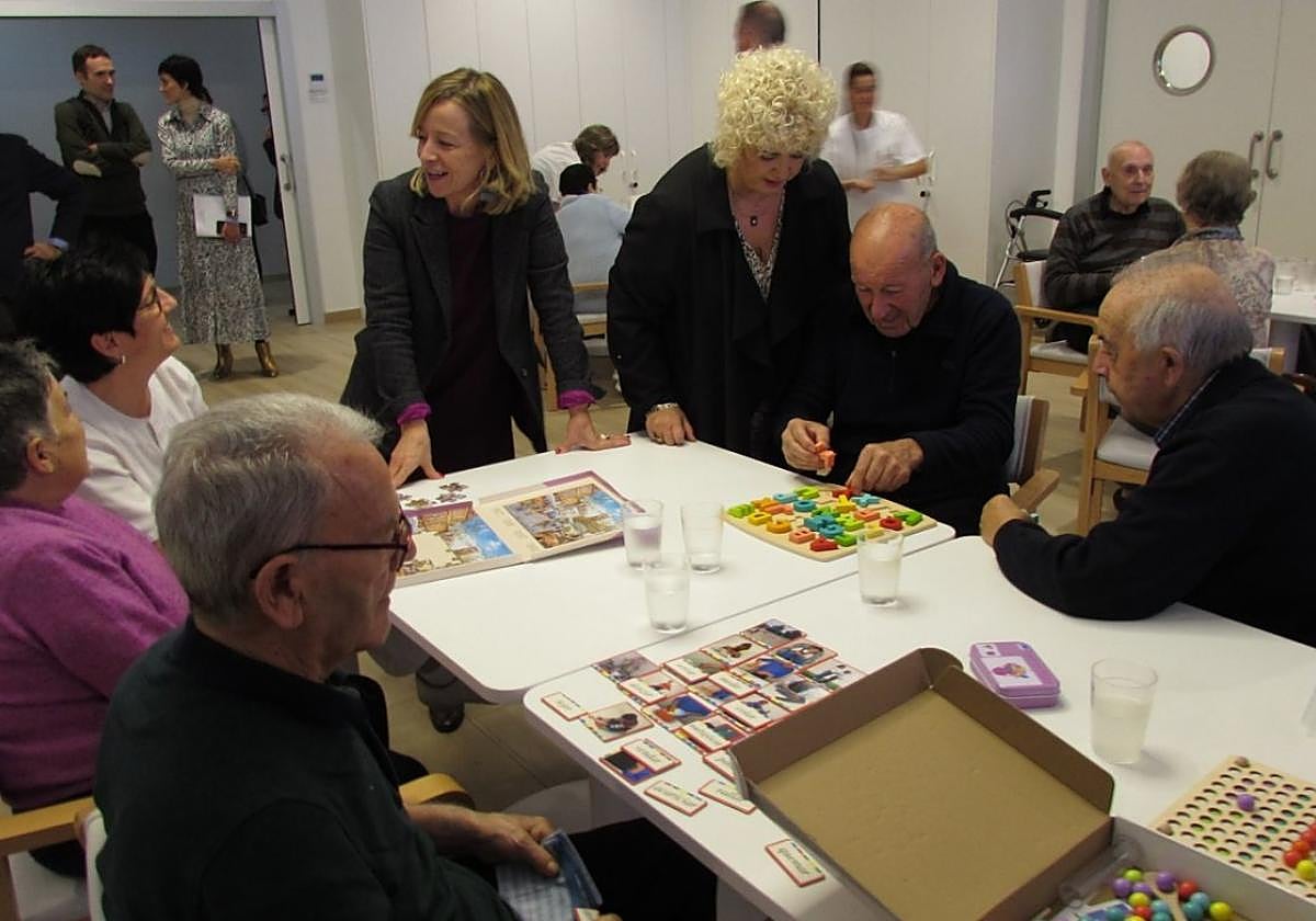 La diputada general Eider Mendoza y la diputada Maite Peña conversan con varios usuarios del centro de día para personas mayores.