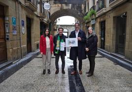 Representantes de la ONCE y el alcalde Eneko Goia, este jueves con el cupón en la calle Puerto.