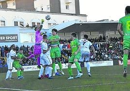 El meta del Ceuta Ramírez despeja de puños ante Le Normand en la eliminatoria de 2020. Barrenetxea, Zubeldia y Merino siguen la jugada.