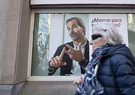 Una mujer pasea por delante de una entidad bancaria.