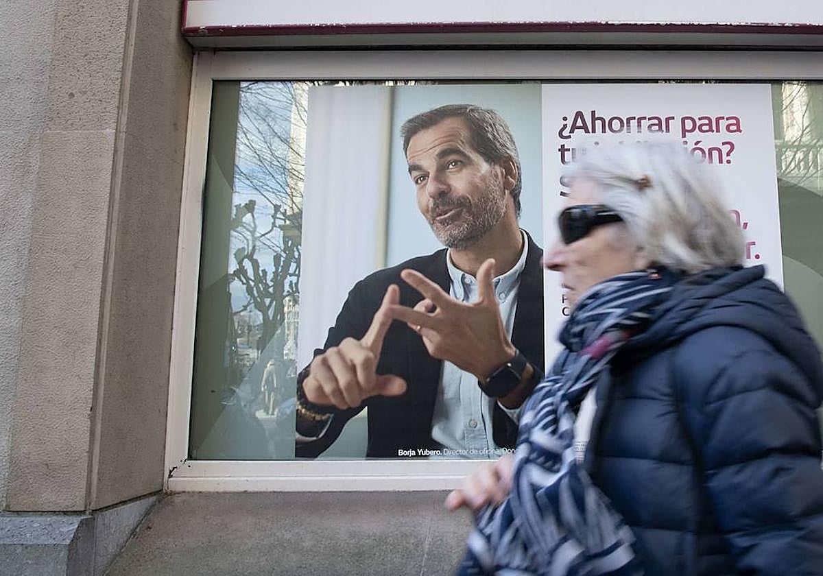 Una mujer pasea por delante de una entidad bancaria.