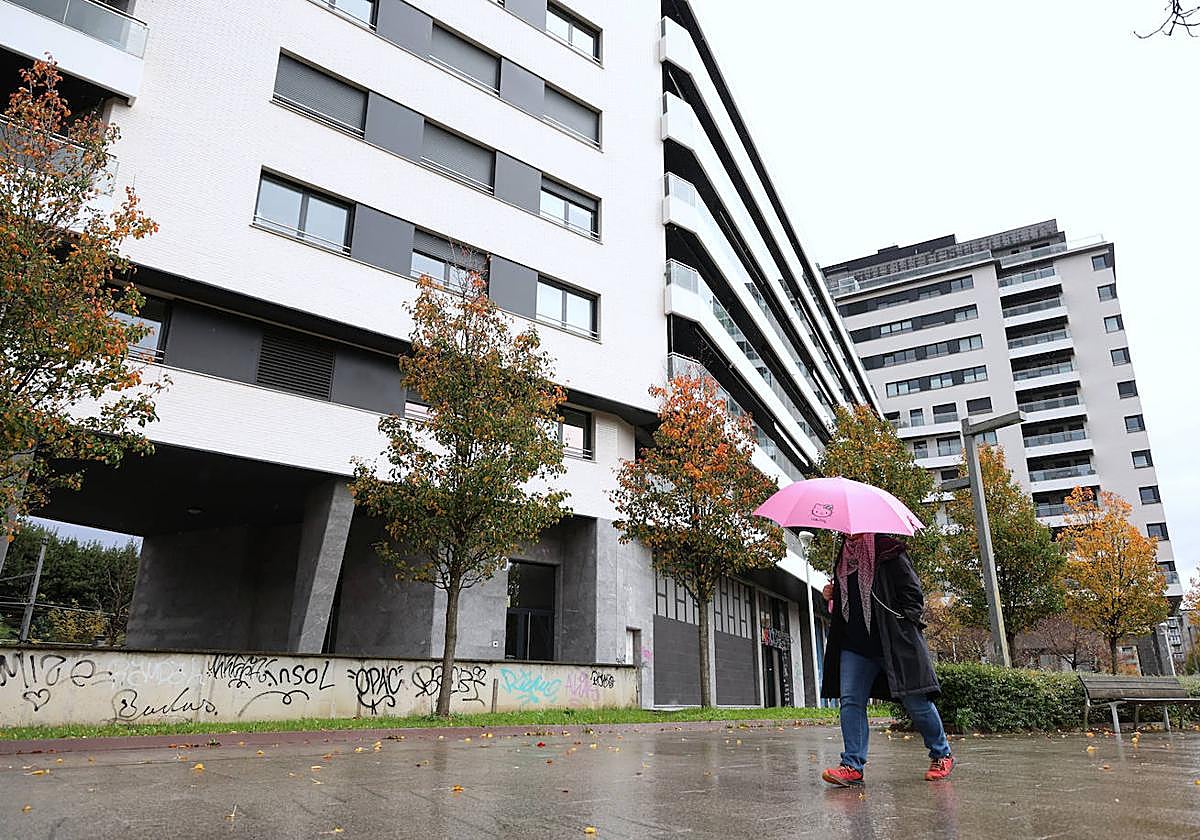 Una mujer pasea frente a los edificios del Paseo de Urumea.