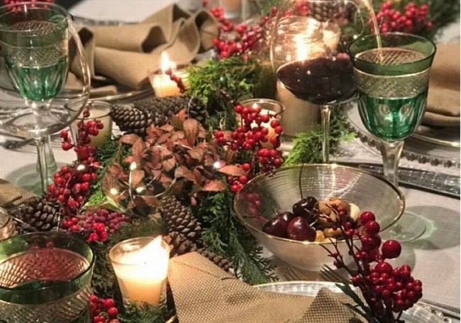 Mesa con centro de mesa con ramas de pino y piñas