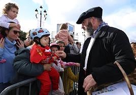 Olentzero y Mari Domingi recorren algunas calles de Donostia montados en un coche antiguo.