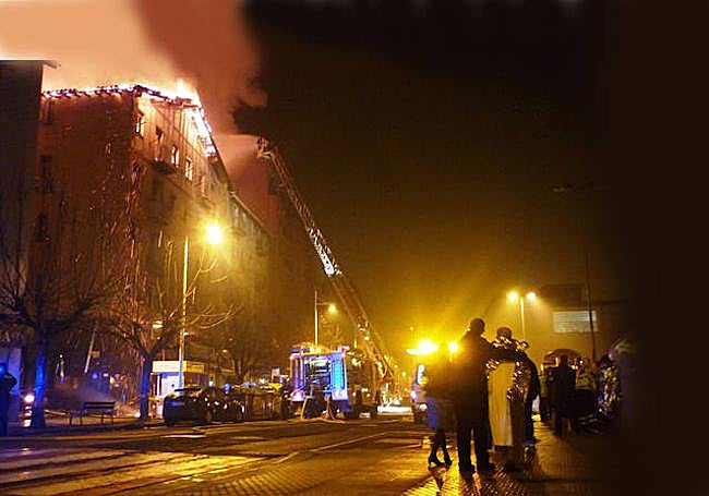 Los vecinos desalojados de los dos bloques de viviendas afectados por el incendio contemplan cómo arden en las primeras horas de 2014.