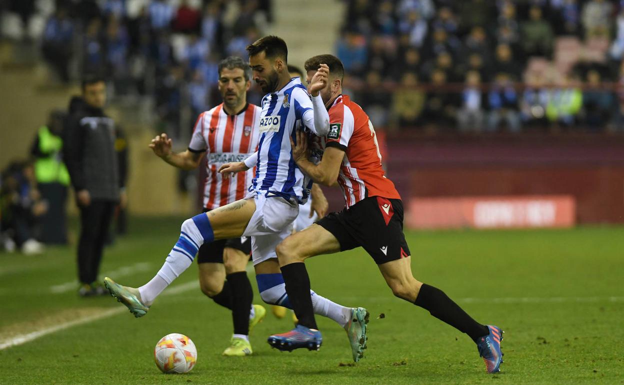 Brais Méndez controla el balón ante dos jugadores del Logroñés. 