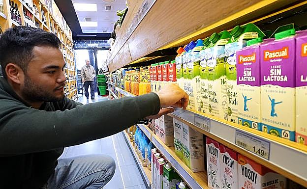 Jeferson, responsable de Súper Matia de Amara Berri, actualizando los precios que se muestran en los lineales de la leche.