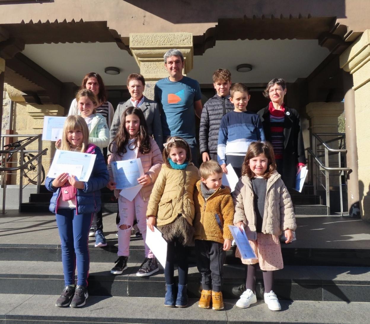 Los premiados posan junto al alcalde con sus diplomas. 