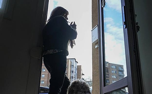 Izar Errandonea enciende un cigarro en la puerta de su casa ante la atenta mirada de Milú. 