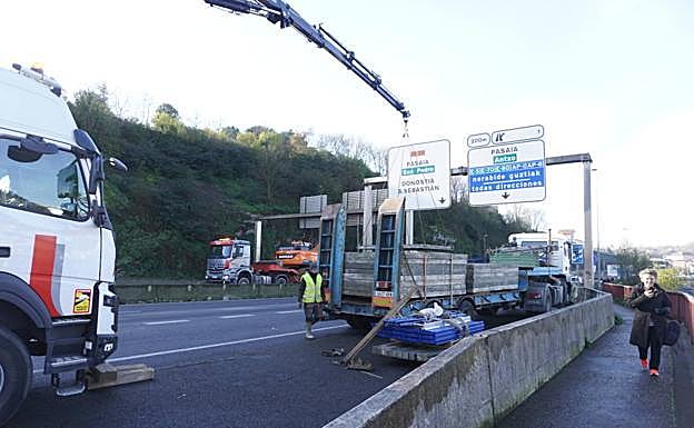 Una grúa retira las piezas metálicas que ha perdido el camión.