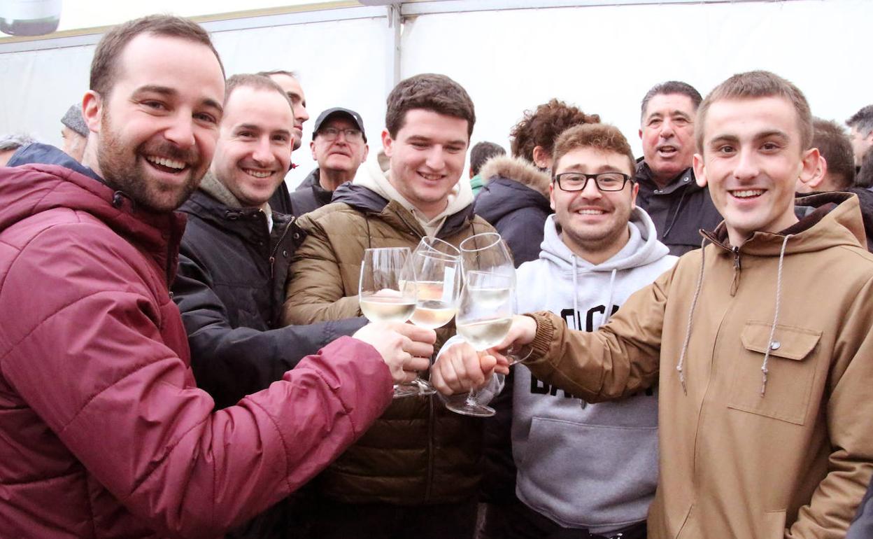 Un grupo de amigos degusta el nuevo txakoli en la carpa instalada en la plaza de Getaria.