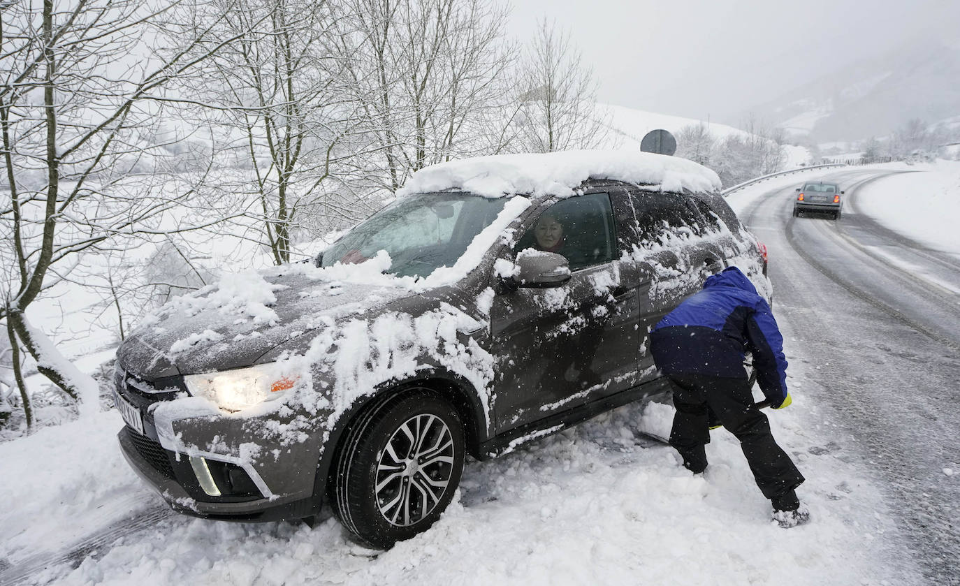 Un hombre intenta sacar su vehículo de la nieve.