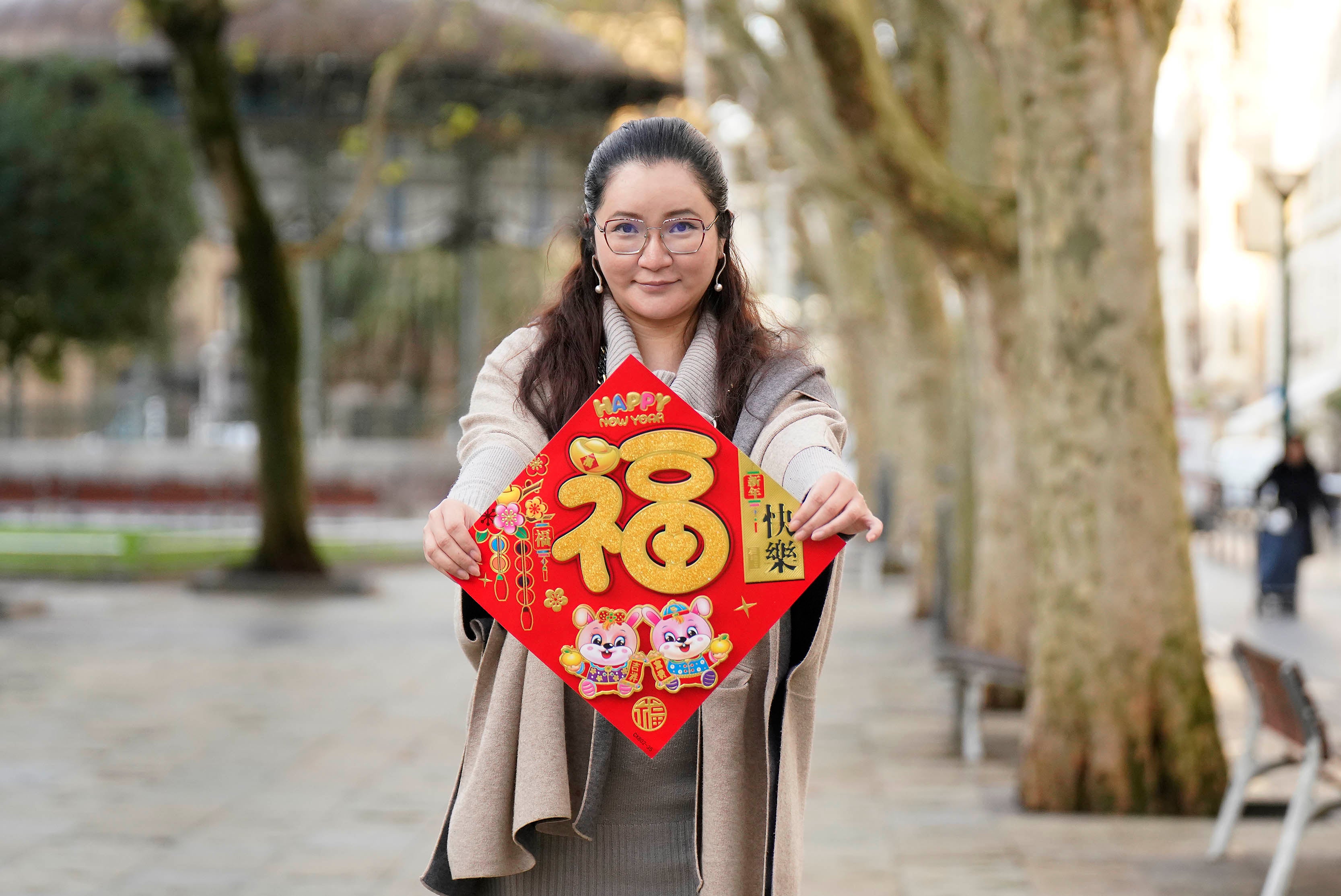 Adela muestra un cartel que da la bienvenida al Año Nuevo Chino.