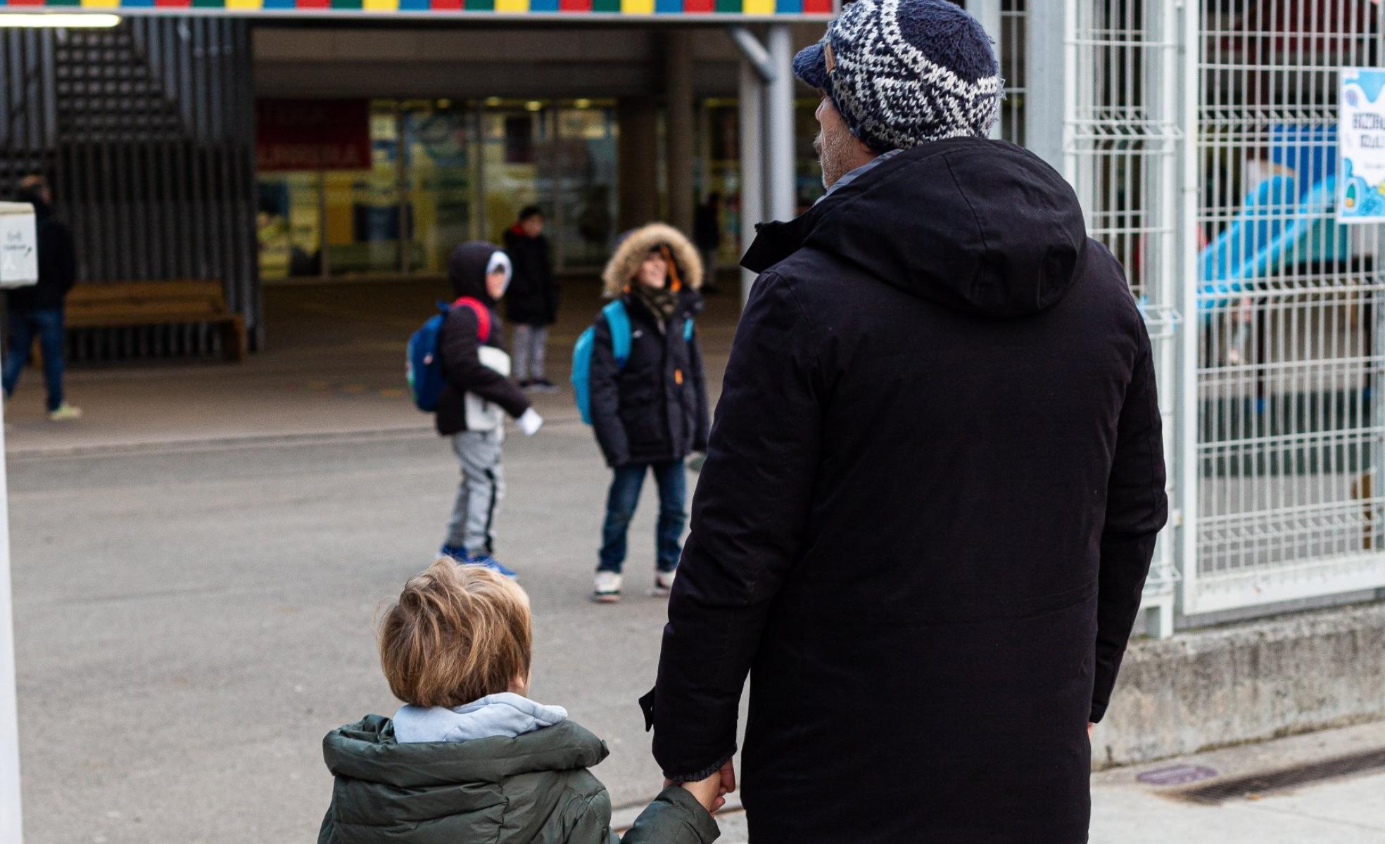 Un hombre lleva a un niño al colegio en Irun.