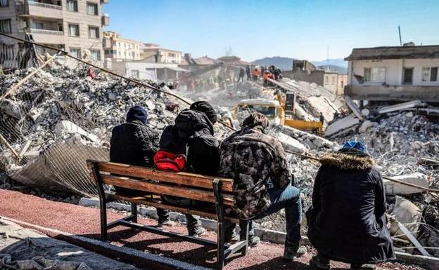 Neighbors watch the demolition of destroyed buildings in Nurdagi.