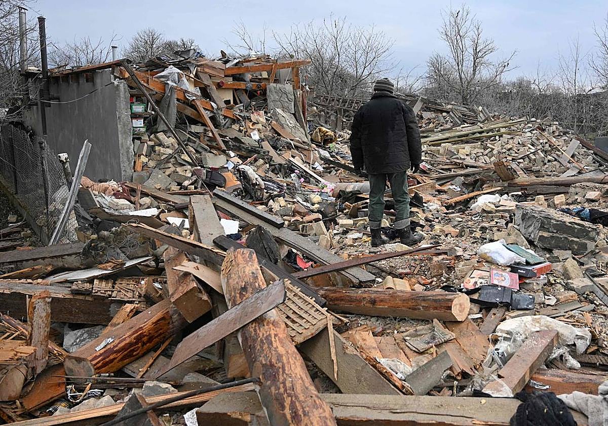Un hombre camina entre los escombros de su pueblo, en Ucrania.
