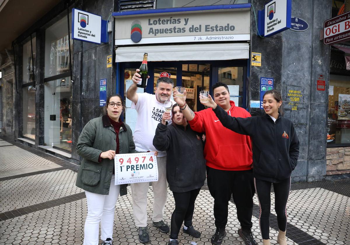 Oriol Villar, con camiseta blanca, celebra el décimo de la Lotería del Niño vendido en su administración.